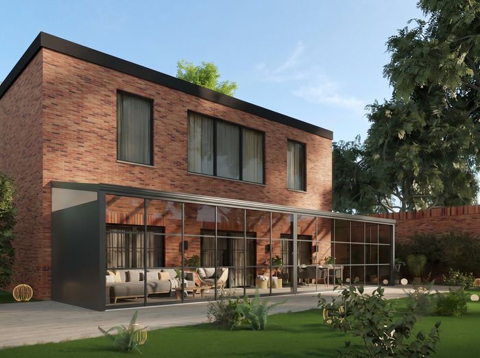 Overkapping met glazen schuifwanden aan een bakstenen woning, in daglicht met tuin en loungeset